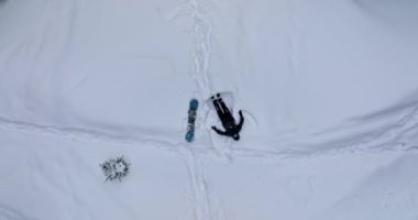 Aerial view of a snowboarder making a butterfly in the snow in winter. High quality DJI Mavic 3 5.1k and 4k footage made in January 2022 in Brasov Romania
