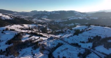 Drone shot of scenic mountains sun peaking over mountains rocky mountains. High-quality DJI Mavic 3 5.1k and 4k footage in January 2022 in Borsa, Romania a town in eastern Maramures County