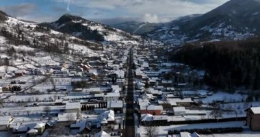 Aerial birds eye view of a small Romanian village with a snow-covered roof in winter. High-quality DJI Mavic 3 5.1k and 4k footage in January 2022 in Borsa, Romania a town in eastern Maramures County