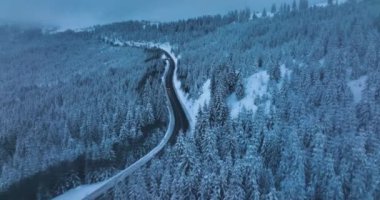 Drone flying over the narrow winding road. Middle of the snow-covered white mountain. High-quality DJI Mavic 3 5.1k and 4k footage in January 2022 in Borsa, Romania a town in eastern Maramures County