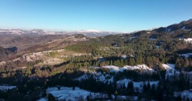Drone shot of scenic mountains sun peaking over mountains rocky mountains. High-quality DJI Mavic 3 5.1k and 4k footage in January 2022 in Borsa, Romania a town in eastern Maramures County
