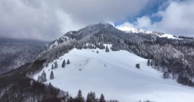 Climbers walking up the mountain expedition aerial flight epic mountain range. High-quality DJI Mavic 3 5.1k and 4k footage made in Romania in February 2022. Beautiful winter hike. Snowy mountain.