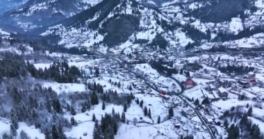A small mountain town is covered in snow on a sunny winter day. Hunedoara Romania. High-quality DJI Mavic 3 5.1k and 4k footage in January 2022 in Borsa, Romania a town in eastern Maramures County