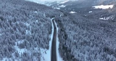Drone flying over the narrow winding road. Middle of the snow-covered white mountain. High-quality DJI Mavic 3 5.1k and 4k footage in January 2022 in Borsa, Romania a town in eastern Maramures County