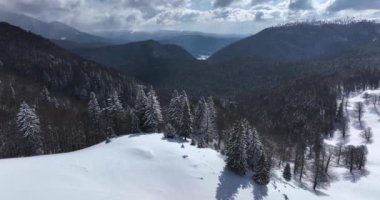 From great heigh fairytale mountain landscape snow covered mountain and peaks. High-quality DJI Mavic 3 5.1k and 4k footage made in Romania in February 2022. Beautiful winter hike. Snowy forest.