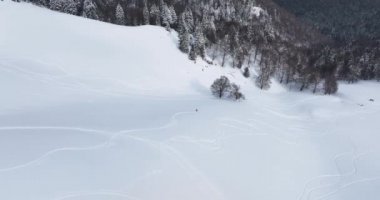 Top-down drone view of a snow-covered mountain landscape at an altitude over 1600. High-quality DJI Mavic 3 5.1k and 4k footage made in Romania in February 2022. Beautiful winter hike. Snowy mountain.