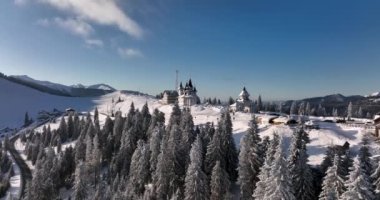 The monastery Pirslop and the Pass In Maramuses are Covered in the snow on a sunny day.High-quality DJI Mavic 3 5.1k and 4k footage in January 2022 in Borsa, Romania a town in eastern Maramures County
