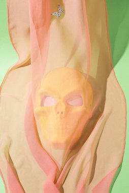 Sarı kafatası ipek bir eşarpla kaplanmış, bir ateşin yandığı izlenimini yaratıyor. Modern renklerin kavramsal arkaplanı.