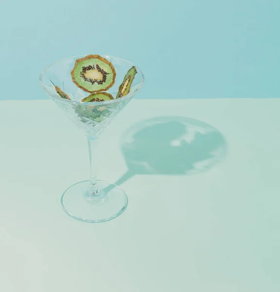 现代静止生活的概念设定 干水果放在鸡尾酒杯里 蓝色背景和绿色猕猴桃 — 图库照片