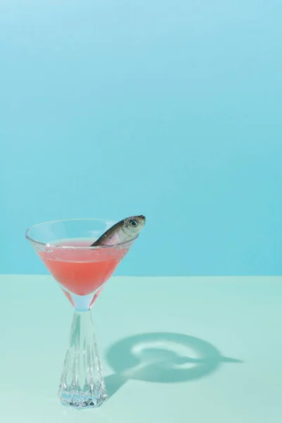 现代静止生活的概念设定 鱼在鸡尾酒和水晶杯 浅蓝色背景 两种色调 — 图库照片