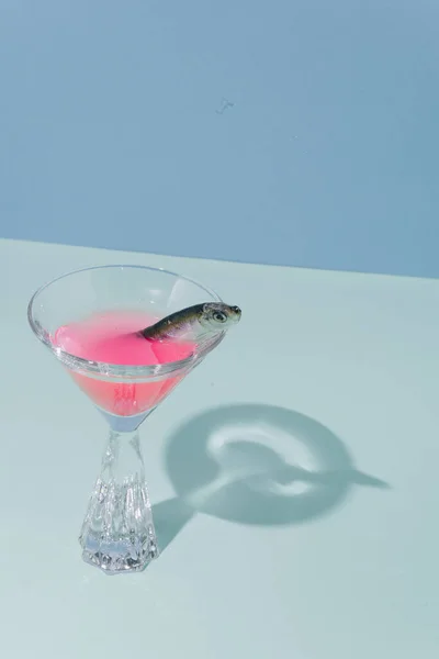 鱼在鸡尾酒杯 具有不同寻常的装饰的世界闻名的大都市 粘糊糊的背景色 影子作为一个元素 概念设定 — 图库照片