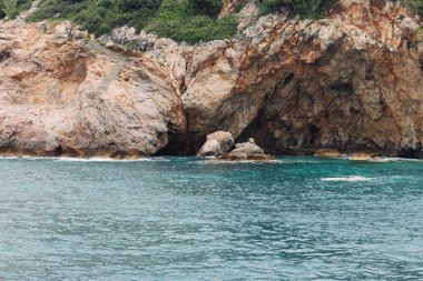 Merdivenleri ve zümrüt deniziyle kayalık sahil