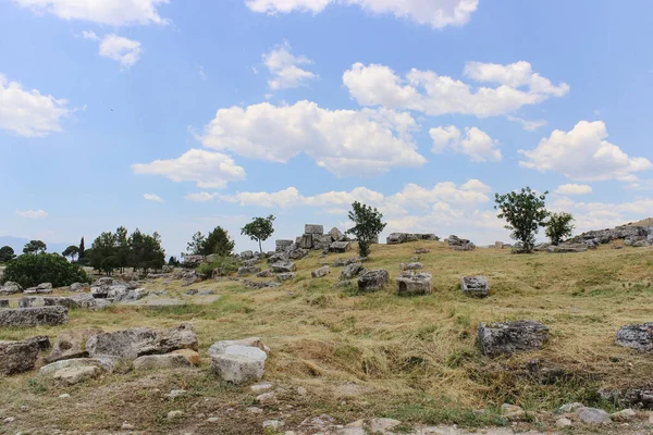 Eski taş kalıntıları ve beyaz bulutlu mavi bir gökyüzü. Peyzaj