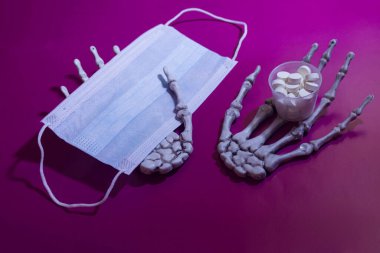 İskelet eller, tıbbi maske ve haplar. Önleme veya tedavi