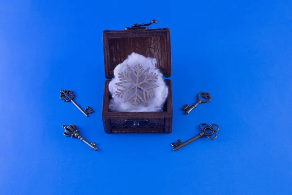 Snowflake Carved Wood Open Casket Keys Next Blue Background — Stockfoto