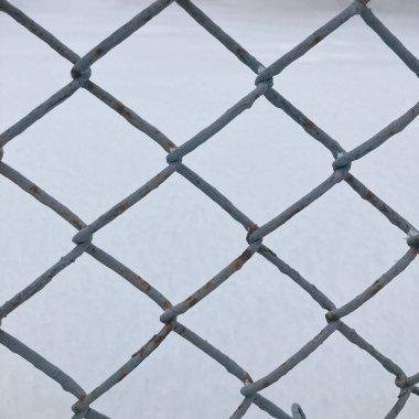 Karla kaplı bir yüzeyin arka planında gri ağ zinciri var.