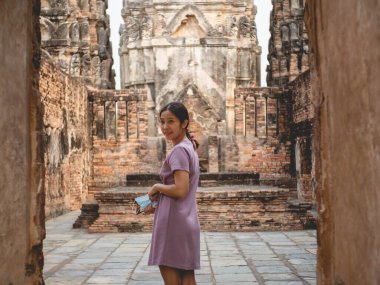 13 Mart 2021 'de Sukhothai, Tayland' da mor elbise ve eski tapınak giyen bir kadın.