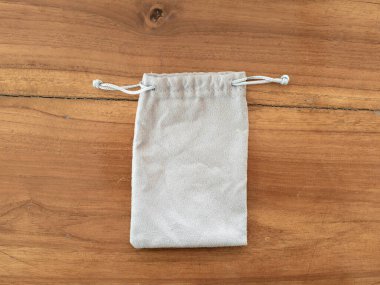 Ahşap zemine koyulmuş gri bez çanta.