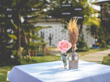 Suyun yanındaki yemek masasında pembe güller.