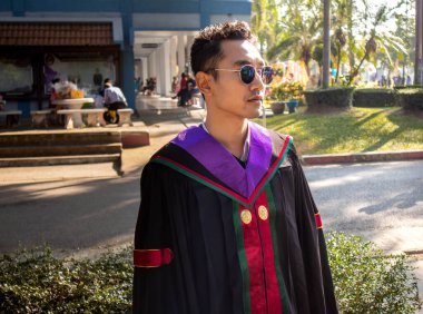 Mezun, Tayland 'daki bir üniversiteden kalma bir elbise giydi. Mezuniyet için