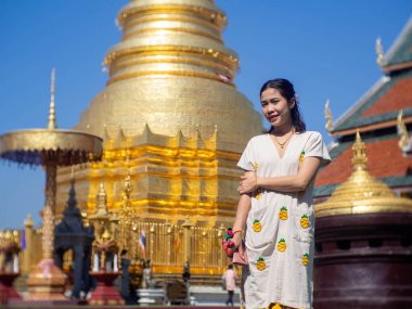 Tapınağın içinde dikilen bir kadın ve arkasında bir pagoda