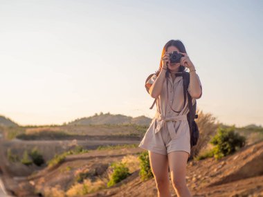 Sırt çantası taşıyan ve fotoğraf çeken bir kadın.