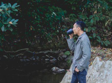 Doğada kahve fincanı olan bir adam