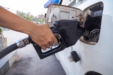 Turuncu ve siyah yağ dağıtıcısıyla el.