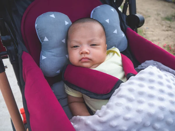 Tayland uyruklu Asyalı bir bebek tekerlekli sandalyede oturuyor.