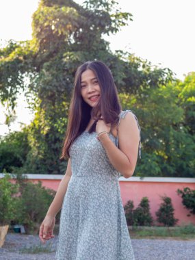 Asyalı bir Taylandlı kadın mavi elbise giyip kendini iyi hissediyor.