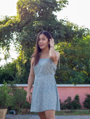 Asyalı bir Taylandlı kadın mavi elbise giyip kendini iyi hissediyor.