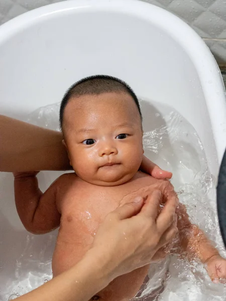 赤ちゃんアジアと国籍タイは白い盆地で入浴しています — ストック写真