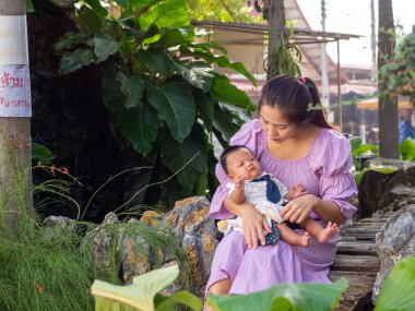 Kadın ve bebek Asyalı ve milliyetçi Tayland mutlu hissettiriyor.