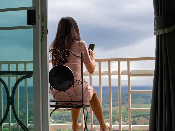 Asain woman sitting on the balcony at Phetchabun, Thailand.