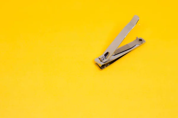 Open Grey Nail Clipper Corner Yellow Background — стокове фото