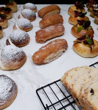 Lezzetli hamur işleri ve çörekler masada.