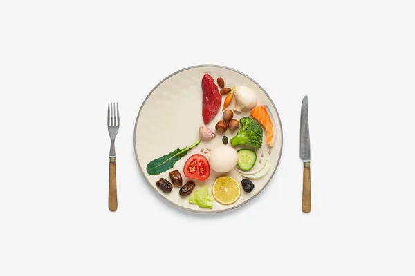 16: 8 perhiz konsepti. Sağlıklı iki üçüncü tabak ve üçüncü tabak boş. Sığır eti, somon, yumurta, brokoli, domates, fındık, havuç, mantar, salatalık, hurma, çatal bıçak. Beyaz arkaplan Boşluğu Kopyala Üst Görünüm
