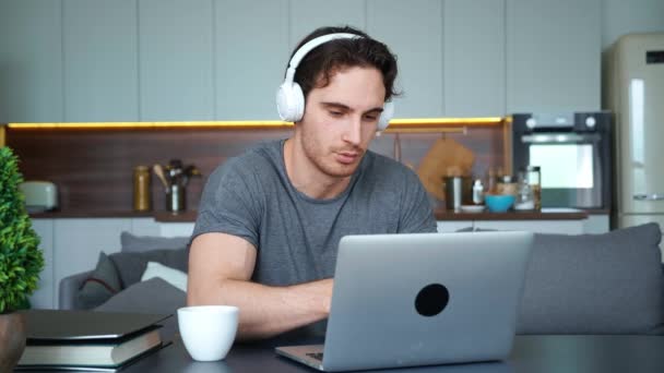 Hombre atractivo guapo empleado freelance, hombre de negocios, estudiante de la universidad en auriculares inalámbricos hablando por videoconferencia a través de aplicación móvil. Conceptos de aprendizaje electrónico y trabajo remoto — Vídeo de stock