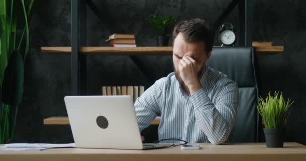 Sorglig affärsman som lider av huvudvärk, har smärtsamma huvudkänslor på grund av bärbar dator överarbete eller stillasittande arbetslivsstil. Trött stressad anställd överväldigad av uppgifter i ämbetet. — Stockvideo