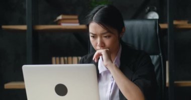 Asyalı iş kadını kötü bir anlaşmayla şoke olmuş, dizüstü bilgisayar ekranına bakıyor, krize tepki veriyor. Ofiste çalışırken bilgisayarda görülen kötü e-postayla hoş olmayan bir şekilde şaşırtılan kadın..
