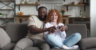 Afrikalı Amerikalı erkek ve Asyalı kadın, bilgisayar oyunu bağımlısı, oyun oynarken joystick 'e tıklayan, izin günlerinde oyun oynarken heyecanlanan. Hafta sonu eğlencesi