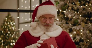 Noel Baba sihirli parlayan hediye kutusunu açar ve içine bakar, kutudan parlak bir ışık parlar. Mutlu yıllar ve Noel.