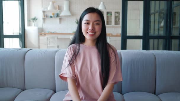 自宅でウェブカメラを使用してビデオチャットを持っている美しいアジアの若い女性は、オンライン通信をチャットを楽しんで生活を共有手を振って.コンピュータ画面表示 — ストック動画