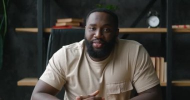 Mutlu genç Afrikalı blog yazarının webcam görüntüsü kamera konuşmasına bakıyor. Video konferansını çevrimiçi sohbete çeviriyor. Bilgisayar uygulaması kayıt bloğu kullanarak evde oturuyor, kapatıyor. Videochat konsepti