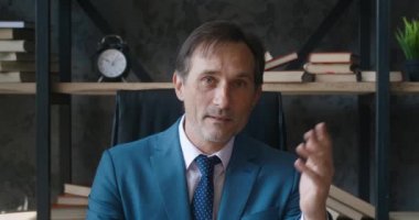 Olgun profesyonel iş adamının kafa resmi, video çağrısını kullanarak çevrimiçi danışmanlık hizmeti sunuyor. İş görüntülü konuşma. Webcam pov kıdemli adam kamerayla konuşuyor, video konferans yoluyla uzaktan danışma