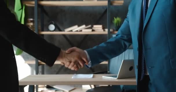 Menutup dua orang pengusaha berjabat tangan, menyimpulkan perjanjian kontrak yang sukses, tanda-tanda dukungan untuk kerja sama kemitraan dengan latar belakang kantor modern — Stok Video