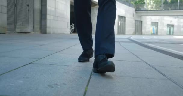 Вид спереди на ноги бизнесмена в черной обуви и формальной одежде, идущего по улице, делающего шаги, ездящего на работу, стреляющего стейдикама. — стоковое видео