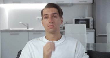 Oturma odasında kanepede oturan kederli, kederli adam. Genç melankolik duygusal genç erkek kanepede oturup ağlıyor..