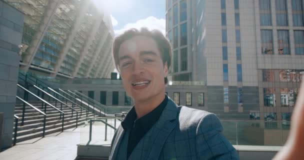 Young business man making selfie video call standing outdoor at business district. Portrait of businessman blogger shooting video blog outdoors near modern office building. — Vídeos de Stock