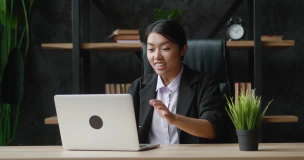 Overjoyed asiático jovem mulher de negócios trabalhando no computador portátil no escritório. Trabalhadora de escritório excitada olhando para tela do monitor lendo ótimas notícias e está encantada. Mostrando sim gesto — Vídeo de Stock